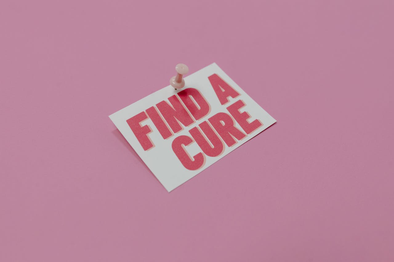 A pink note pinned with message 'Find a Cure', symbolizing cancer awareness.